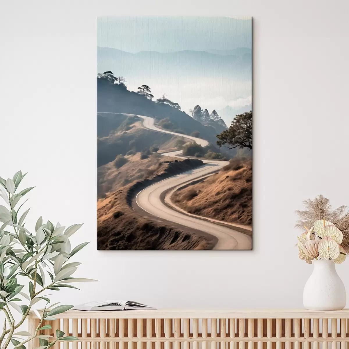 Obraz Klikatá silnice vedoucí kopcovitou krajinou s suchou trávou pod jasnou oblohou a horami v dálce Č. s46289