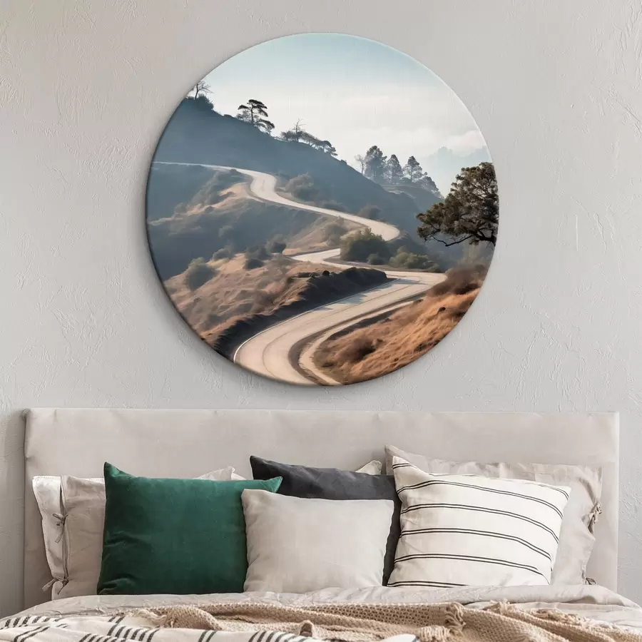 Obraz Klikatá silnice vedoucí kopcovitou krajinou s suchou trávou pod jasnou oblohou a horami v dálce Č. r46289